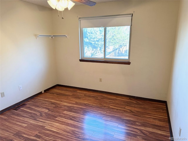 empty room with ceiling fan and dark wood-type flooring