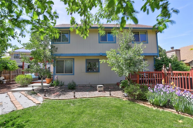 rear view of house featuring a deck and a yard