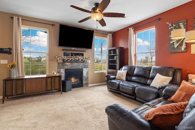 living area with baseboards, ceiling fan, light carpet, and a fireplace