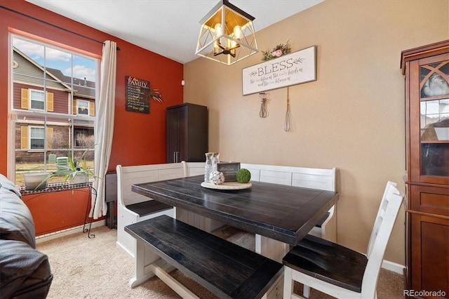 dining room with baseboards, a notable chandelier, and light carpet
