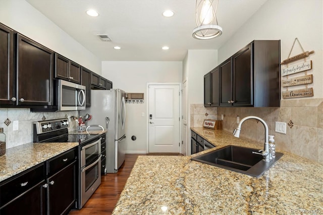 12744 Leyden St Unit F, Thornton, CO 80602 - kitchen with stainless steel appliances, tasteful backsplash, light stone countertops, dark wood-style floors, and dark brown cabinetry