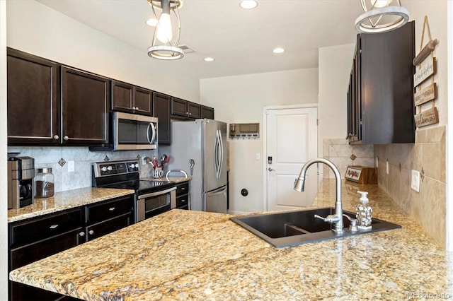 12744 Leyden St Unit F, Thornton, CO 80602 - kitchen with appliances with stainless steel finishes, decorative backsplash, dark brown cabinetry, recessed lighting, and a peninsula
