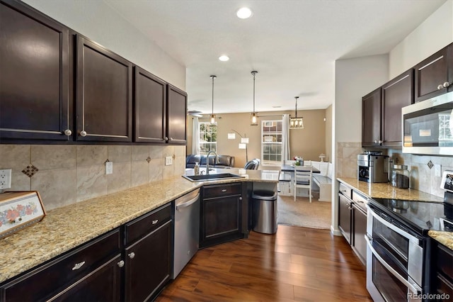 12744 Leyden St Unit F, Thornton, CO 80602 - kitchen with stainless steel appliances, backsplash, a peninsula, dark brown cabinetry, and recessed lighting