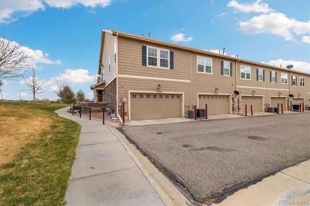 12744 Leyden St Unit F, Thornton, CO 80602 - view of front of house with a front yard, an attached garage, and driveway