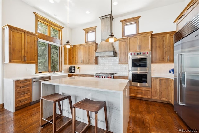 6194 Falcon Ridge Way, Morrison, CO 80465 - kitchen featuring stainless steel appliances, a center island, decorative backsplash, a kitchen breakfast bar, and hanging light fixtures