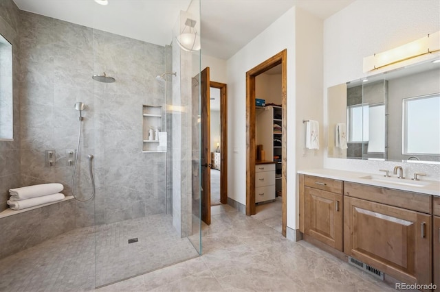 6194 Falcon Ridge Way, Morrison, CO 80465 - bathroom featuring vanity, walk in shower, a spacious closet, and marble look tile flooring