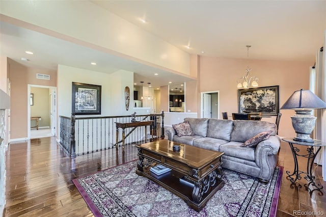 living room featuring hardwood / wood-style flooring, high vaulted ceiling, and a chandelier