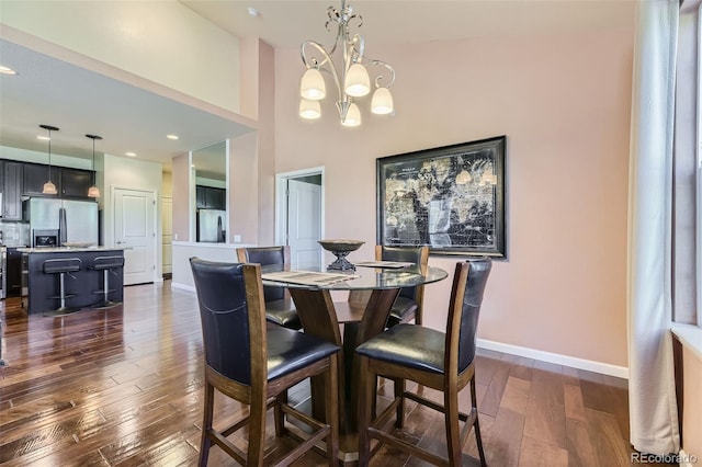 dining room featuring dark hardwood / wood-style flooring and an inviting chandelier