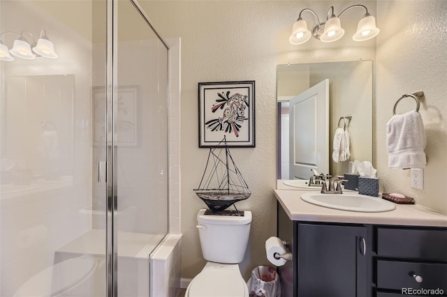 bathroom featuring a shower with door, vanity, and toilet