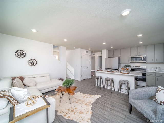 13588 E 103rd Pl, Commerce City, CO 80022 - living area featuring recessed lighting, stairway, a textured ceiling, and wood finished floors