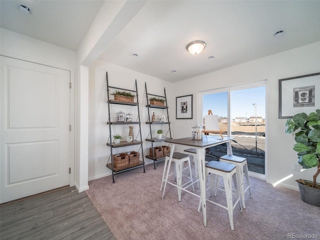 dining space featuring baseboards and wood finished floors