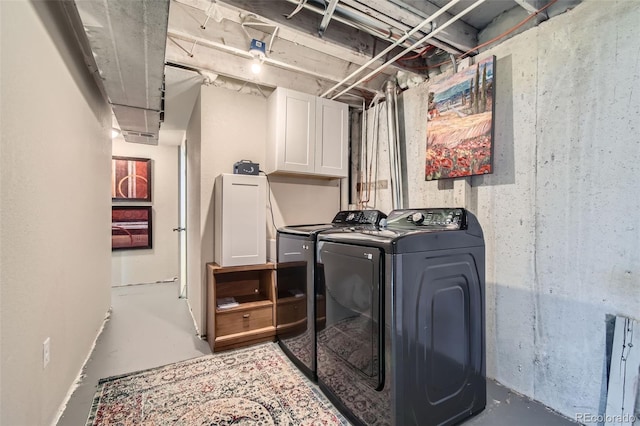 laundry room featuring independent washer and dryer and cabinets