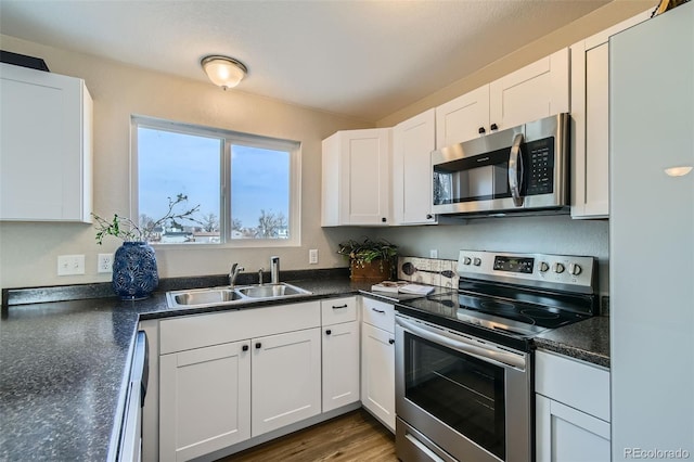 kitchen featuring sink, white cabinetry, stainless steel appliances, and hardwood / wood-style floors