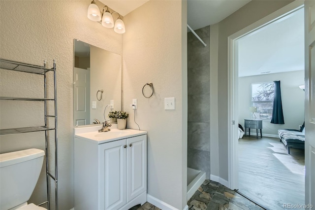 bathroom featuring a shower, toilet, and vanity