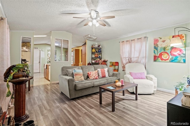 living room with a textured ceiling, ceiling fan, vaulted ceiling, and hardwood / wood-style floors