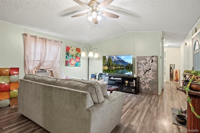 living room with ceiling fan, vaulted ceiling, crown molding, hardwood / wood-style flooring, and a textured ceiling