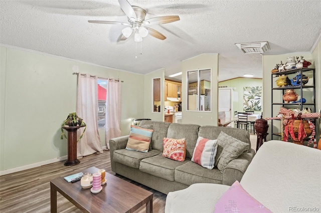 living room featuring ceiling fan, vaulted ceiling, a textured ceiling, and hardwood / wood-style floors