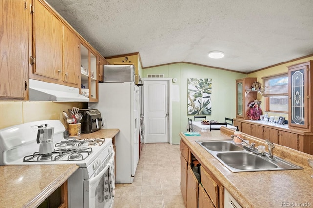 kitchen with lofted ceiling, a textured ceiling, ornamental molding, white gas range oven, and sink