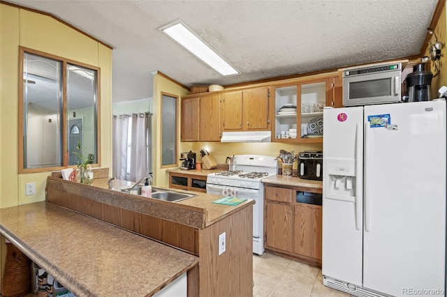 kitchen with light tile patterned floors, white appliances, lofted ceiling, a textured ceiling, and sink