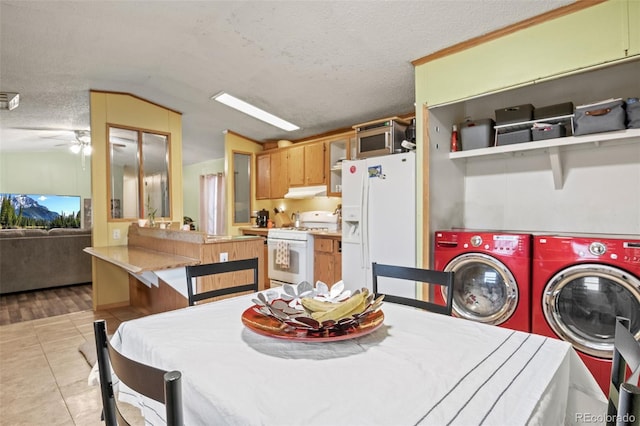 dining area featuring vaulted ceiling, independent washer and dryer, a textured ceiling, and light tile patterned flooring