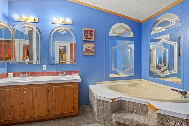 bathroom featuring a textured ceiling, a bathing tub, ornamental molding, and vanity