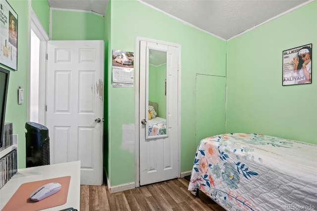 bedroom featuring hardwood / wood-style flooring, a textured ceiling, and lofted ceiling