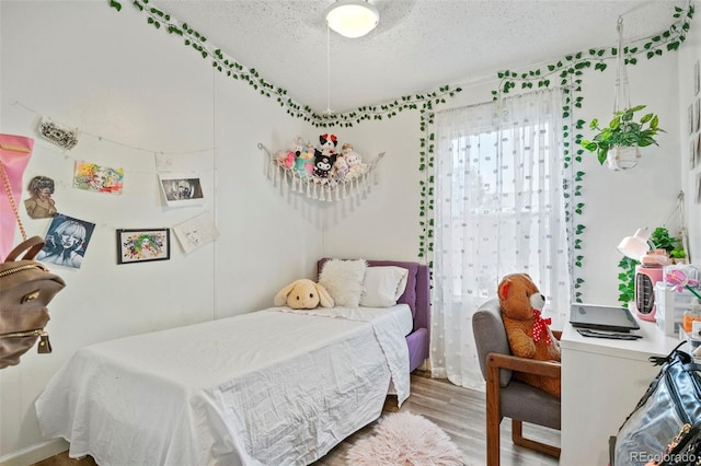 bedroom featuring a textured ceiling and hardwood / wood-style floors