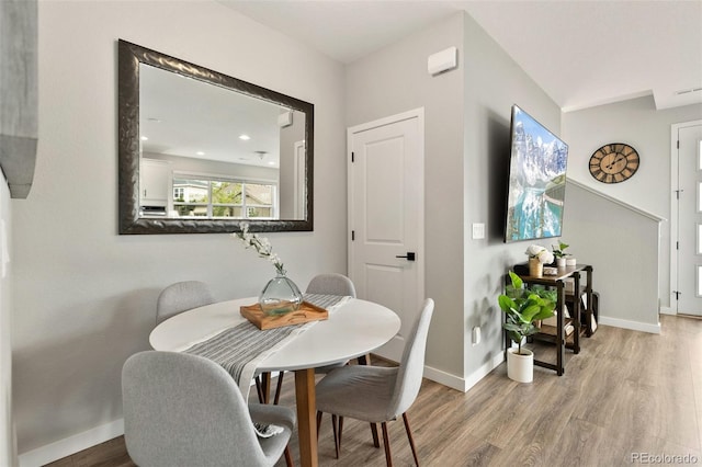 dining space featuring wood finished floors and baseboards