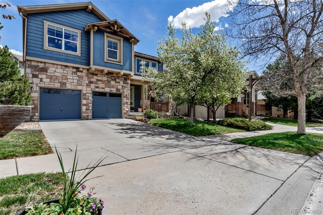 view of front of house featuring an attached garage, driveway, and stone siding