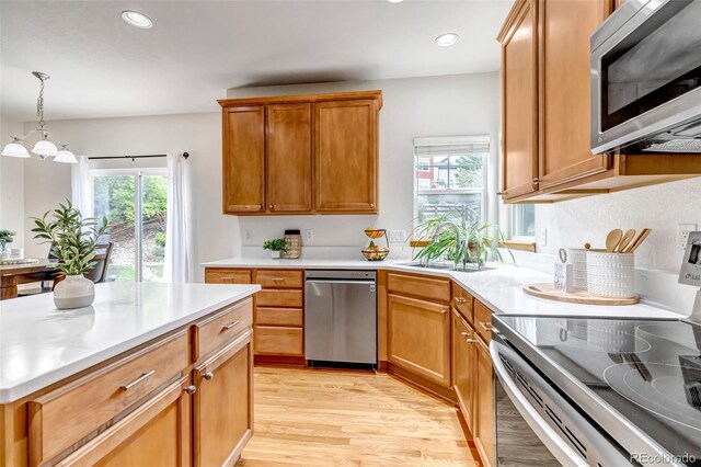 kitchen featuring light countertops, stainless steel appliances, and light wood-style flooring