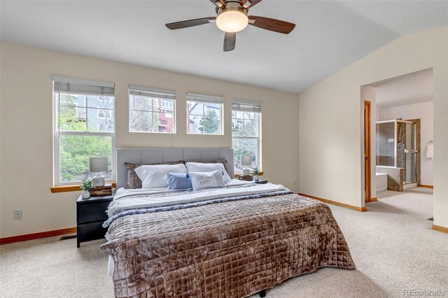 bedroom featuring baseboards, light colored carpet, ensuite bathroom, and lofted ceiling