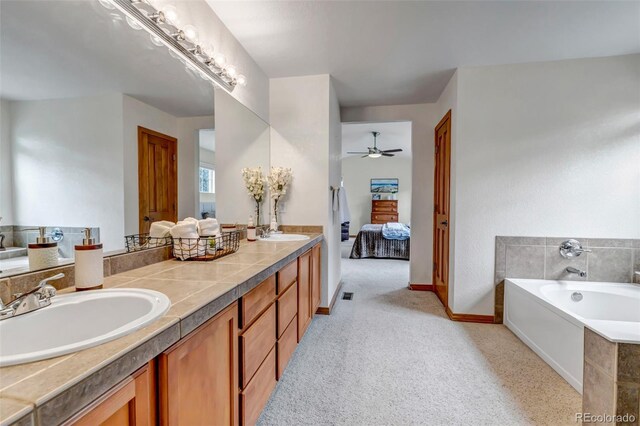 full bathroom featuring a bath, ceiling fan, a sink, and ensuite bathroom