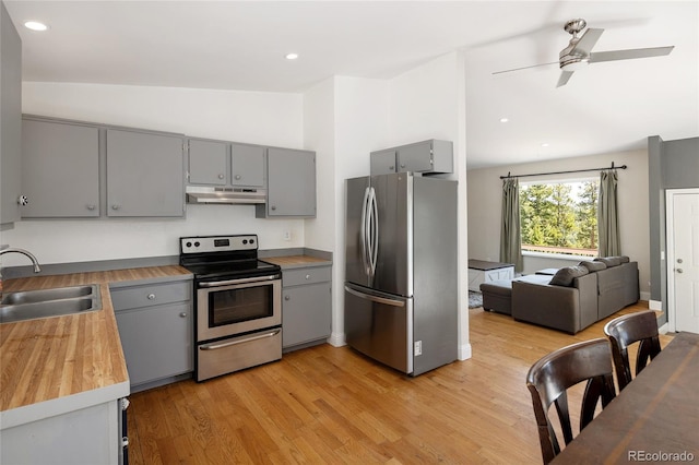 9123 Gray Ln, Conifer, CO 80433 - kitchen featuring appliances with stainless steel finishes, gray cabinets, under cabinet range hood, vaulted ceiling, and light wood-style flooring