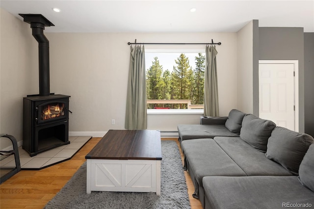 9123 Gray Ln, Conifer, CO 80433 - living room featuring light wood-type flooring, a wood stove, a baseboard radiator, and recessed lighting