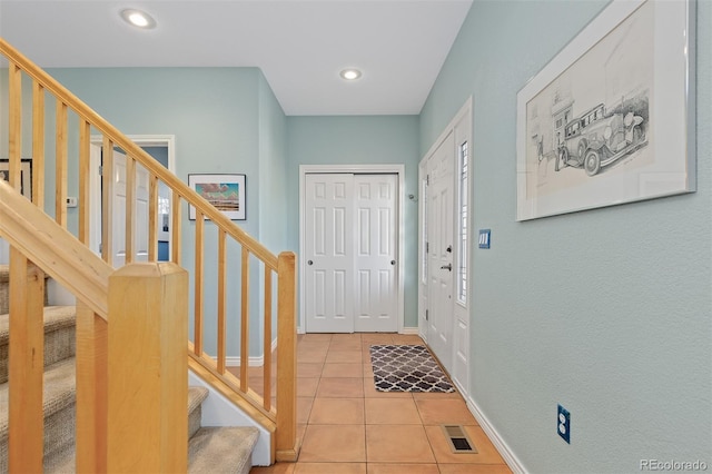 tiled foyer featuring recessed lighting, visible vents, stairway, and baseboards