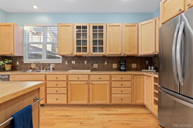 kitchen featuring light brown cabinets, light countertops, a sink, and freestanding refrigerator