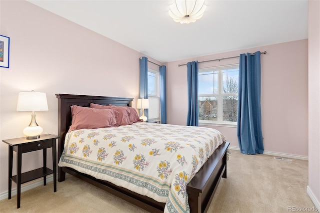 bedroom featuring baseboards, visible vents, and light colored carpet