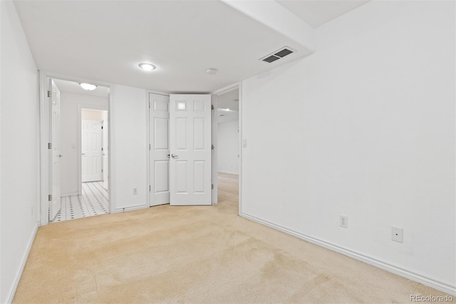 unfurnished room with carpet, visible vents, and baseboards