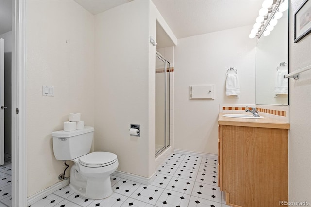 bathroom featuring baseboards, a shower stall, toilet, and vanity