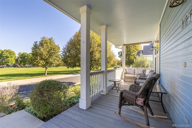 deck featuring a porch and a yard