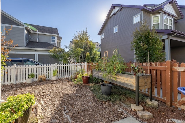 view of yard featuring fence and a vegetable garden