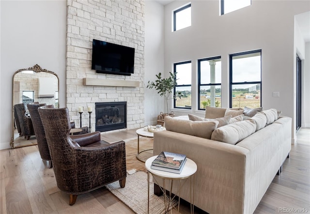 living room with a fireplace, plenty of natural light, and light hardwood / wood-style floors