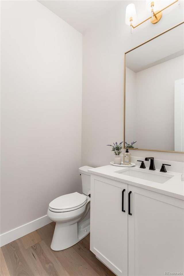 bathroom featuring toilet, hardwood / wood-style floors, and vanity