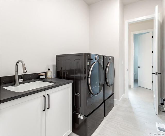 washroom featuring sink, light tile patterned flooring, and washer and clothes dryer