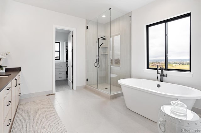 bathroom with plus walk in shower, tile patterned flooring, and vanity