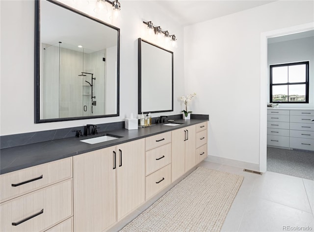 bathroom featuring tile patterned flooring, dual vanity, and walk in shower