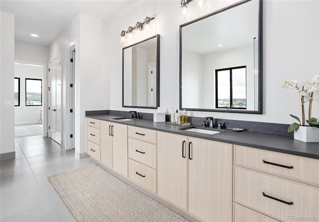 bathroom with a wealth of natural light, dual bowl vanity, and tile patterned floors