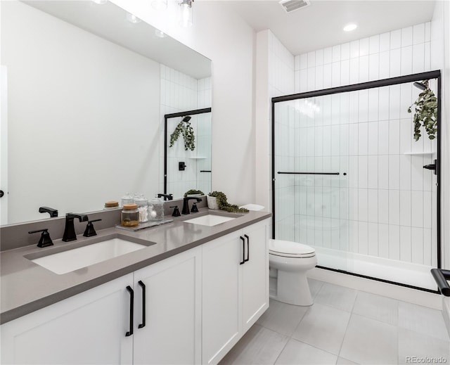 bathroom featuring tile patterned floors, toilet, walk in shower, and dual bowl vanity