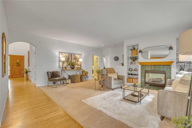 10356 Lions Heart, Lone Tree, CO 80124 - living area featuring arched walkways, wood finished floors, and a tiled fireplace