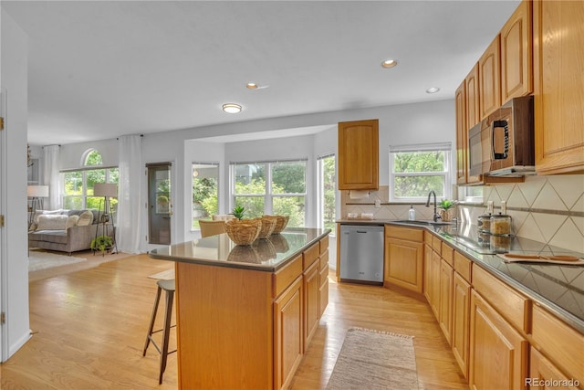 10356 Lions Heart, Lone Tree, CO 80124 - kitchen with stainless steel dishwasher, a kitchen bar, plenty of natural light, light wood-style flooring, and recessed lighting